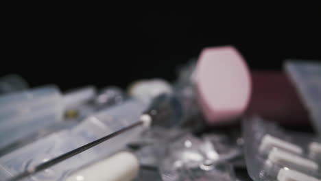 aguja de jeringa por ampollas de plástico entre los medicamentos en negro