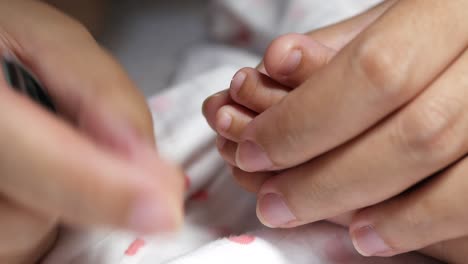 a caring moment as a parent gently trims a baby girl's nails ensuring her safety and comfort.
