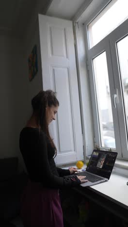 mujer trabajando desde casa en una computadora portátil