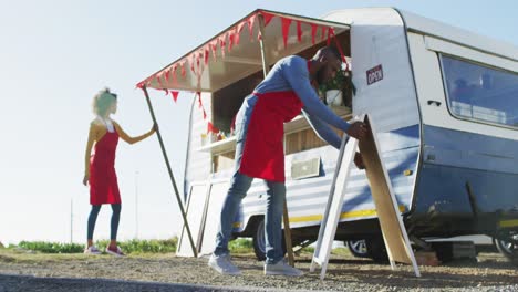 African-american-couple-wearing-aprons-setting-up-their-food-truck-on-the-street