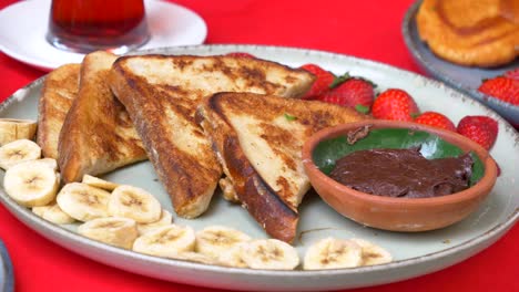 una deliciosa tostada francesa con fresas, plátanos y chocolate