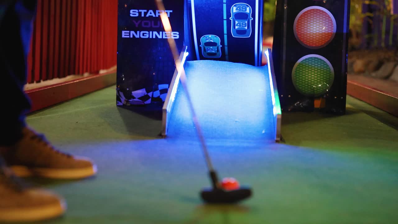 Una vivace scena di minigolf con luci al neon brillanti e un tentativo di putt su un piccolo campo