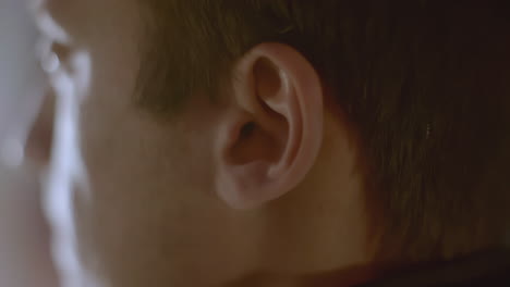 closeup of a person's ear and hand