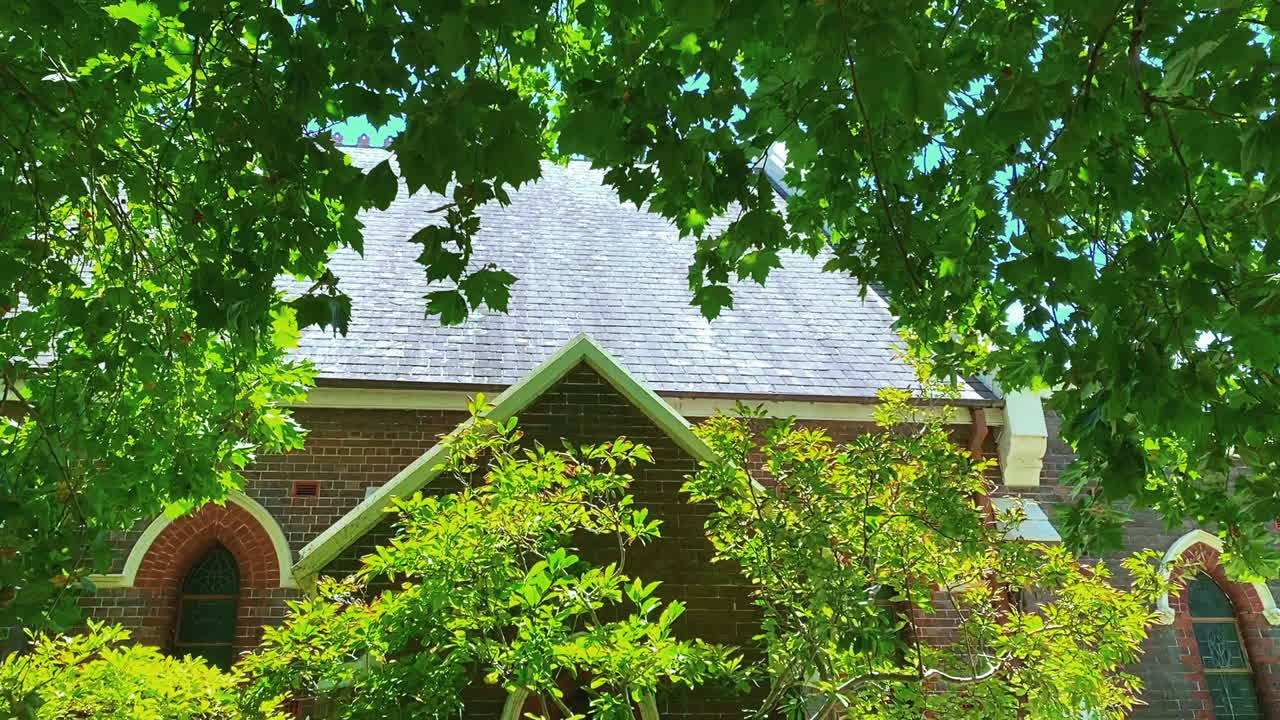 Lush Green Foliage In Front Of An Old Church - medium shot