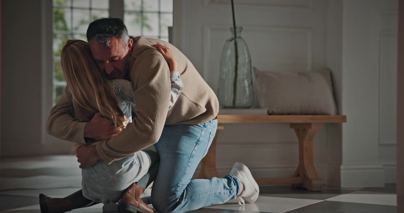 Father Kneeling and Embracing His Young Daughter at Home
