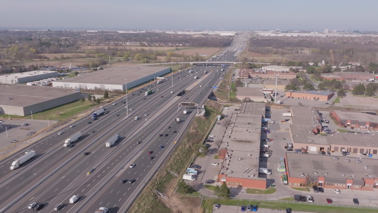 The highway 401 in mississauga, canada, showing traffic and industrial buildings, aerial view