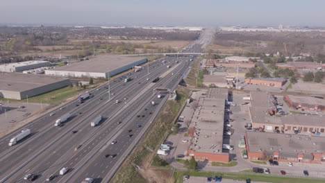 the highway 401 in mississauga, canada, showing traffic and industrial buildings, aerial view