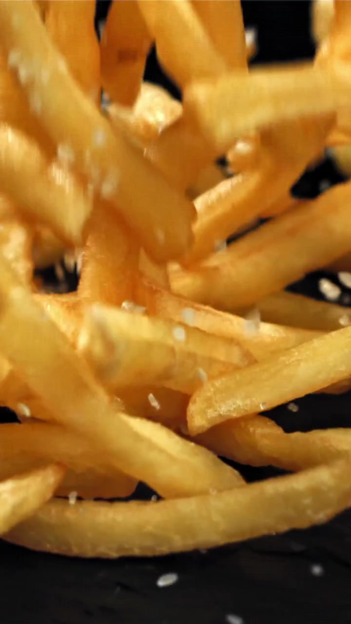 Crispy Golden French Fries Falling and Seasoned with Salt