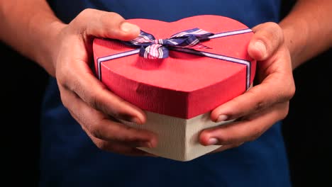 person holding a heart-shaped gift box