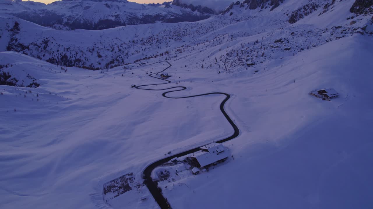 Aerial shot of snow-draped Dolomites mountains during sunset, Italy
