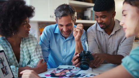 Male-And-Female-Team-Of-Fashion-Designers-With-Laptop-Meeting-In-Modern-Office