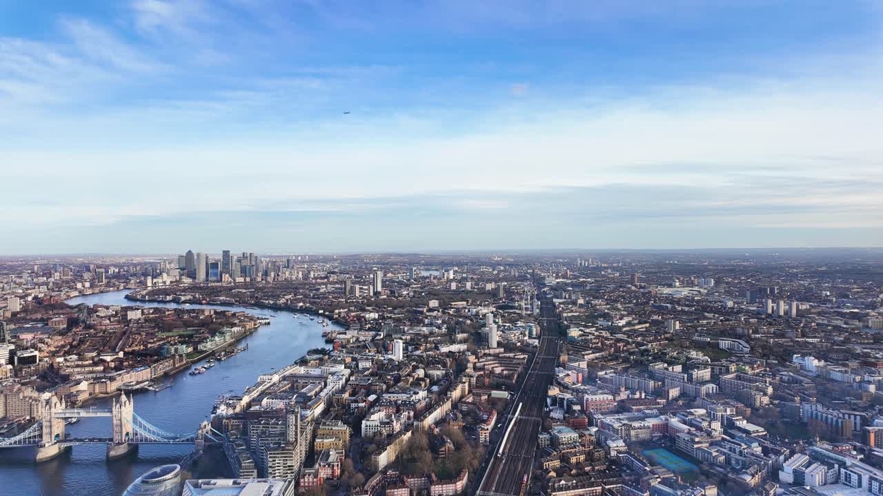 Timelapse of Tower Bridge and Canary Wharf skyline, showing London's modern and historic architecture with trains rushing along tracks and ferries in water