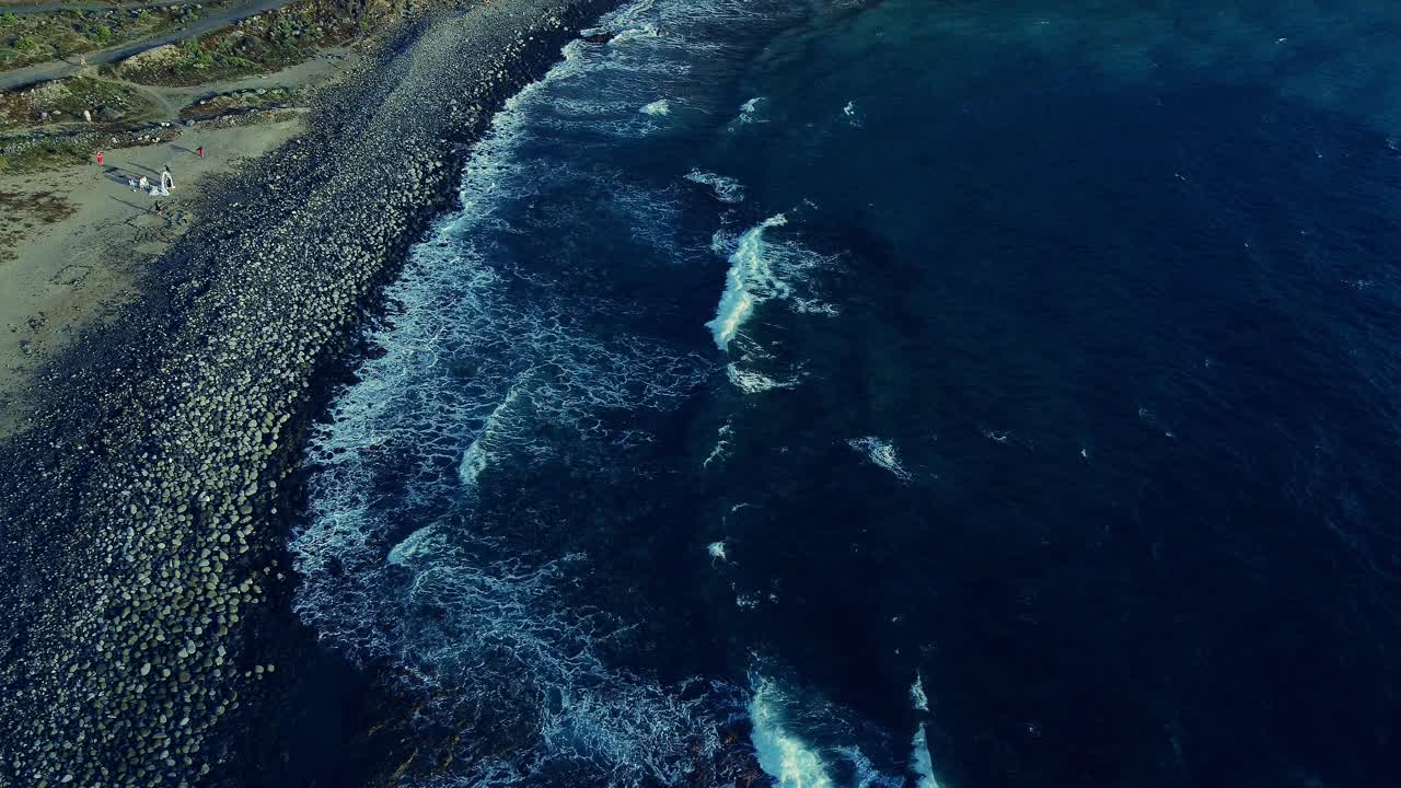 toma aérea de ondas tropicales en la playa de guijarros de los cristianos, tenerife, canarias, españa
