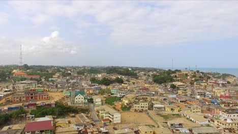 Hermosa-Vista-Aérea-De-Drones-4k-De-Una-Ciudad-Costera-Africana-Con-Edificios-Coloridos-En-La-Costa-Del-Cabo,-Ghana,-áfrica-Occidental