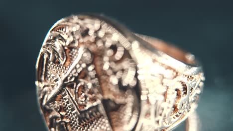 a macro detailed tilt down shot of a golden textured freemasons ring, on a rotating stand, mirror reflection, illuminati symbol, professional studio lighting, 4k video