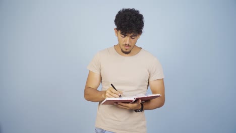 man with notebook thinks and takes notes.