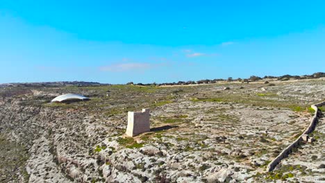 Drone-shot-over-rocks-in-nature-and-towards-a-stone-tower-2-on-the-island-of-Malta