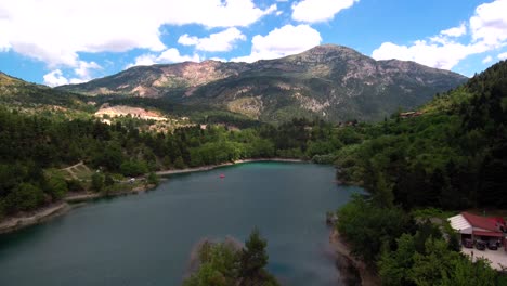 Aerial-dolly-in-shot-flying-above-lake-Tsivlou-in-Peloponnese-mountains-of-Greece-with-a-bright-overcast-sky