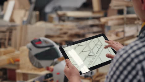 woodworker reviewing design on tablet in workshop