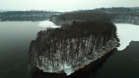 Slightly-frozen-lake-and-snow-covered-forest-from-a-bird's-eye-view