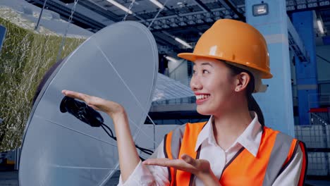 engineer presenting satellite dish in factory