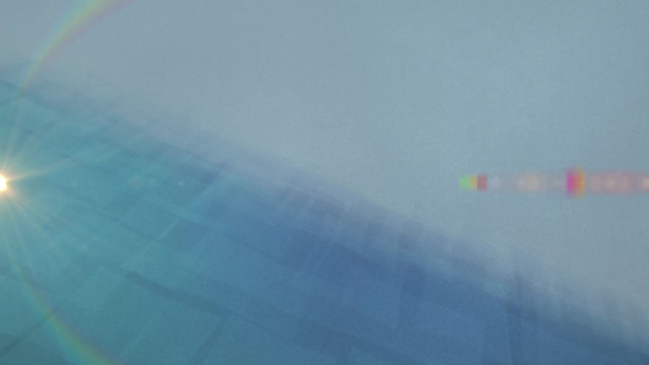 파란색 배경의 추상적인 모양에 대한 무지개 렌즈 플레어의 애니메이션