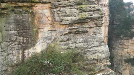 Ascending-aerial-view-captures-Zhangjiajie-National-Park-in-Wulingyuan,-Hunan,-China,-showcasing-the-renowned-Karst-Mountains-famously-recognized-as-the-Avatar-Hallelujah-Mountains