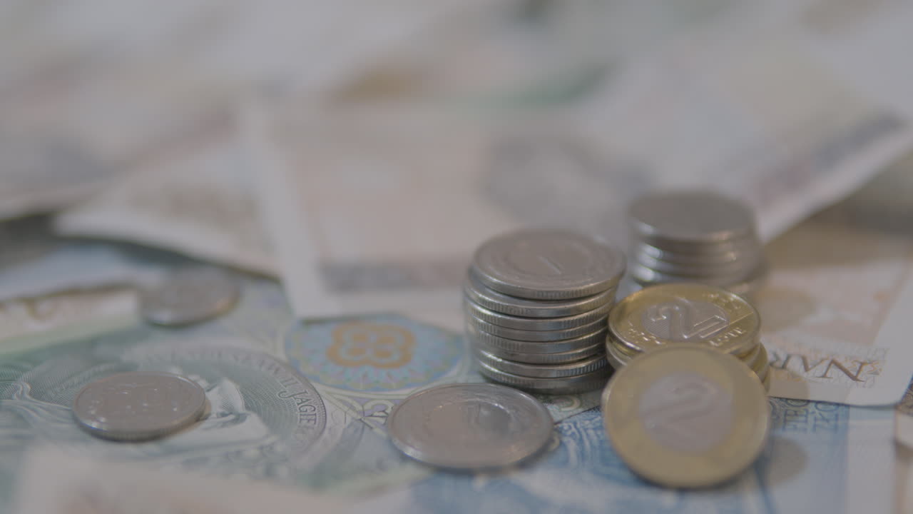 monedas polacas apiladas en billetes - concepto de dinero