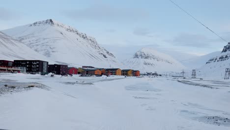 snowmobile driving in the distance outside of the city of longyearbyen in svalbard. static shot.