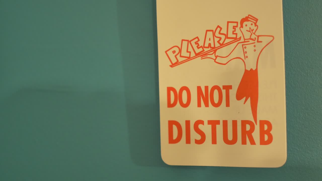 빈티지는 루트 66 모텔의 청록색 문에 걸려있는 표지판을 방해하지 마십시오