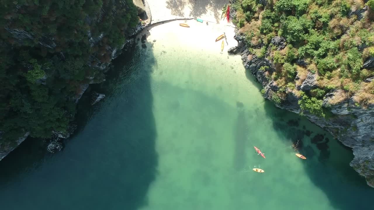 Aerial Over Kayakers Rowing Out In Waters In Halong Bay, Vietnam. Follow Shot
