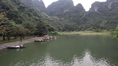 tourists rowing boats in a mountainous lake setting