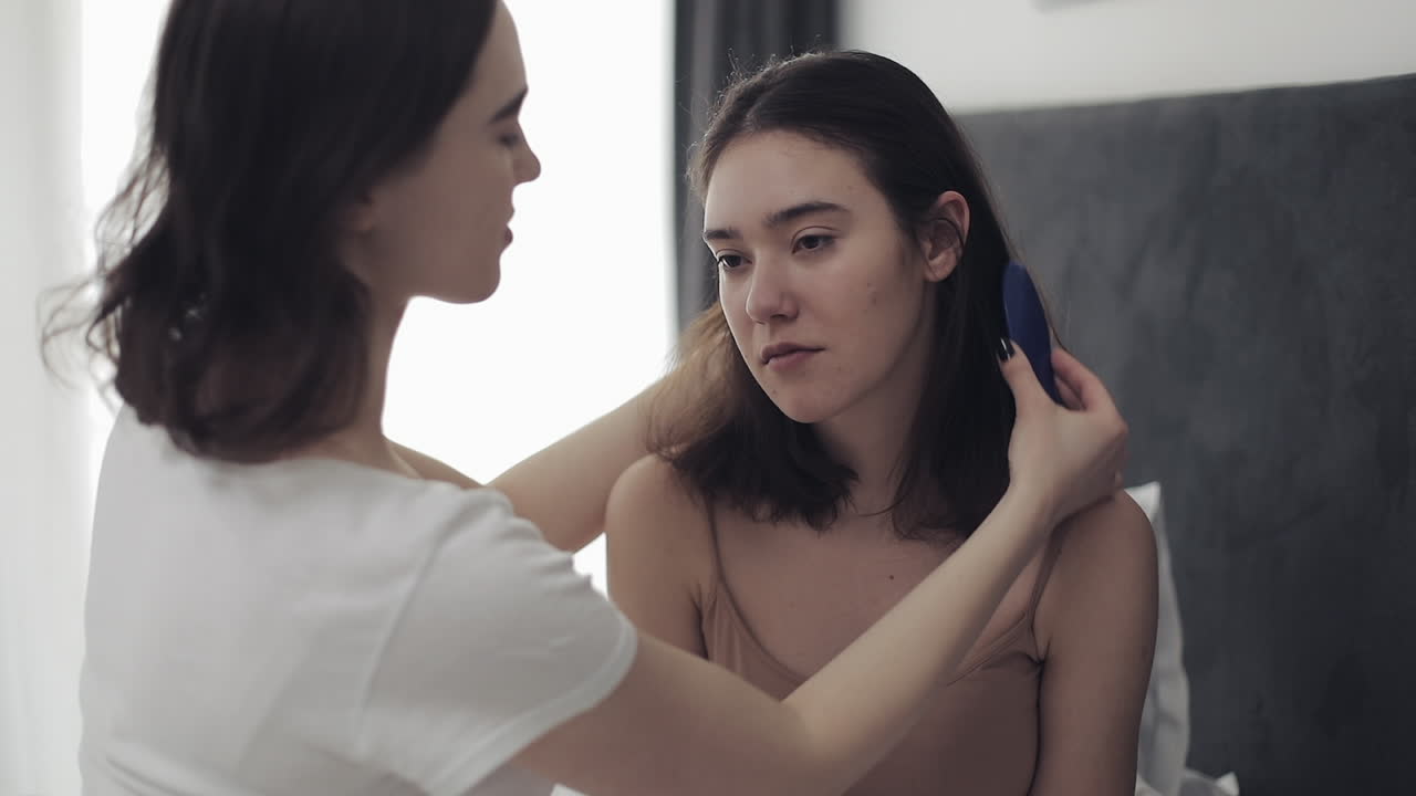 Woman brushing another woman's hair