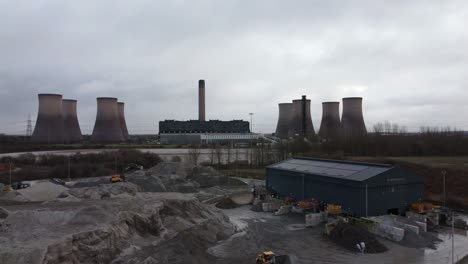 aerial dolly view across coal fired power station site, fiddlers ferry smokestack overcast skyline