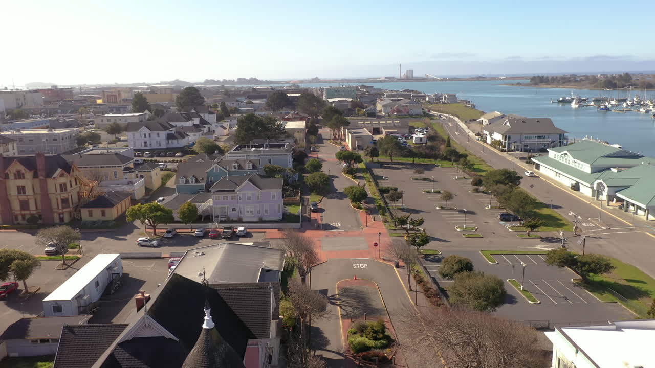 Old historic Victorian houses in downtown Eureka next to waterfront, drone backwards