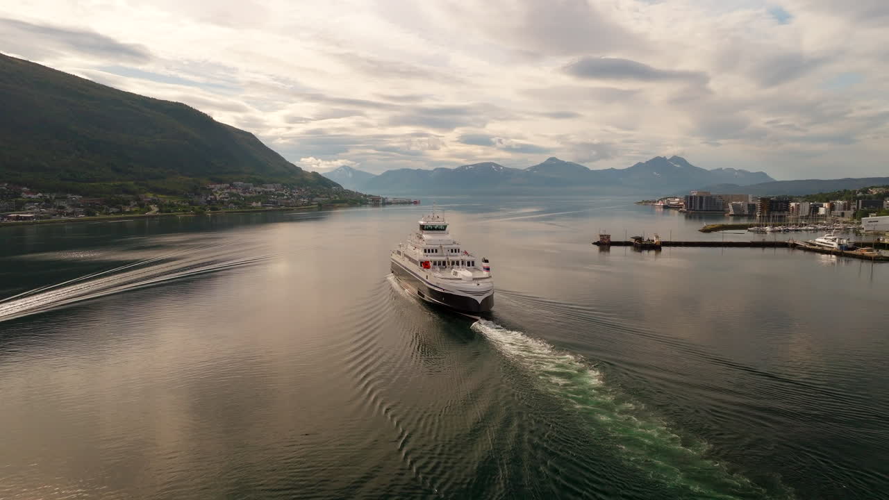 Fuldt elektrisk MF Hinnøy-færge afgår fra Tromsø-kystlinjen om sommeren, set bagfra i luften
