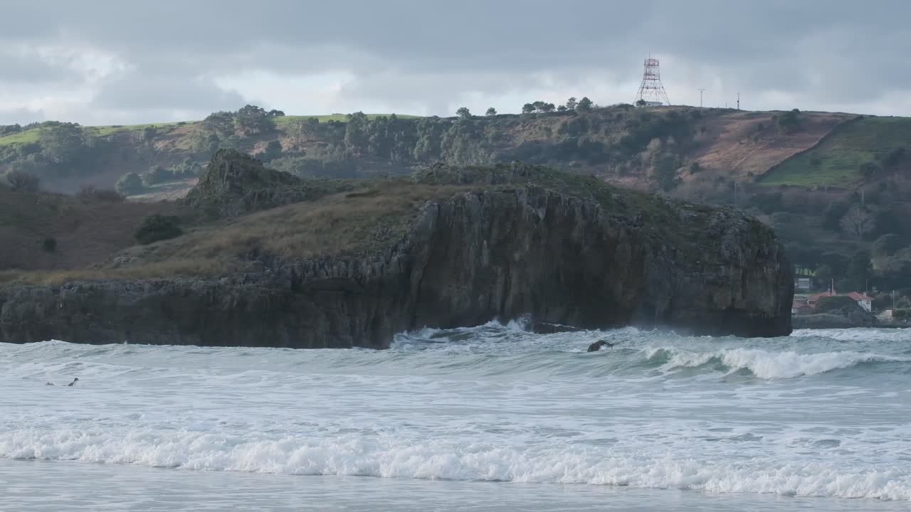 beautiful slow motion footage of waves crashing into the ocean with the rocky coastline in the background