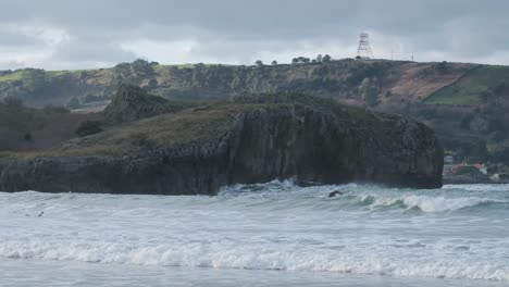 beautiful-slow-motion-footage-of-waves-crashing-into-the-ocean-with-the-rocky-coastline-in-the-background