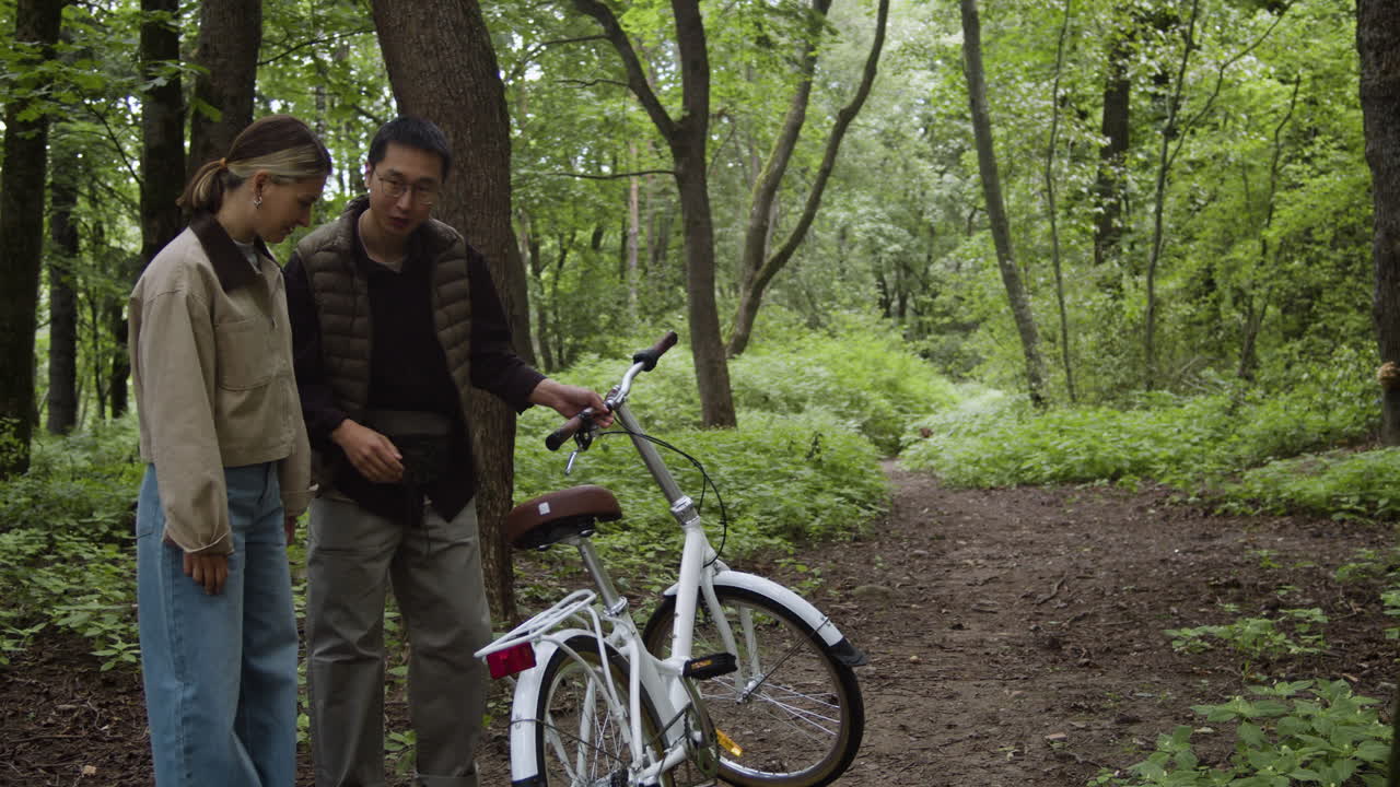 Couple with a bicycle in a forest