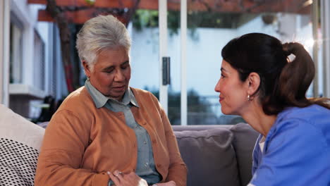 una enfermera hablando con una mujer mayor