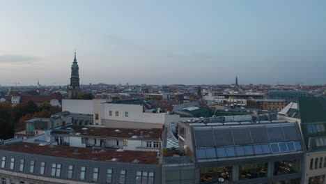 Low-flight-above-roofs-of-modern-buildings-in-town.-Development-contrasting-with-historic-landmarks.-Berlin,-Germany