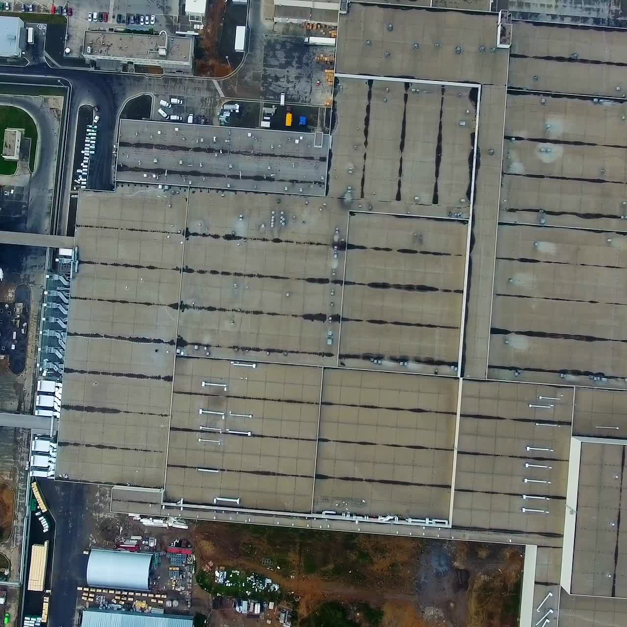 Industrial plant outdoors. Large factory on field. Roofs of buildings of modern industrial plant. Top down. Aerial view.