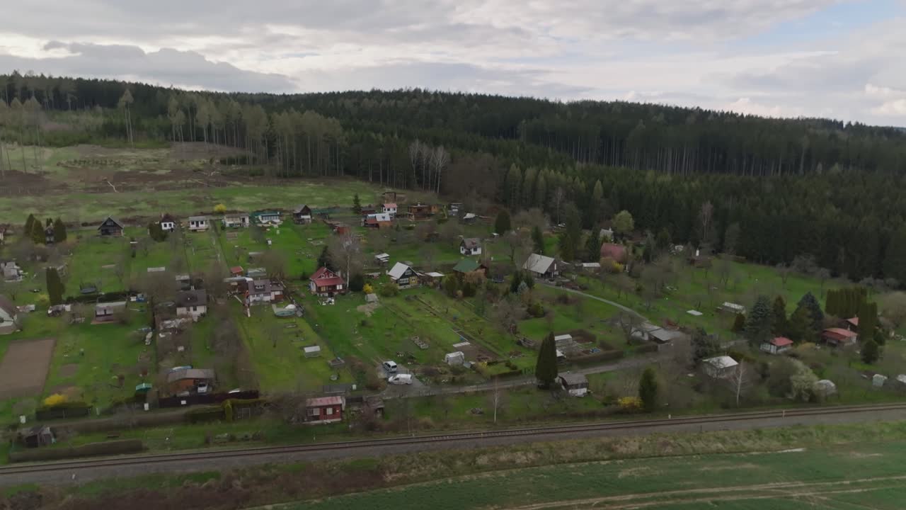 pequeña aldea con casas en una colina en un claro en el bosque