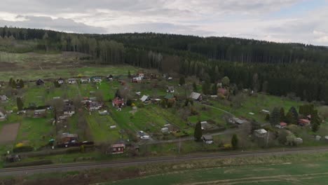 small village with houses on a hill in a clearing in the forest