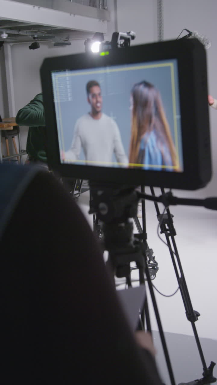 video vertical de asistente femenina usando clapperboard como actores filman una película o video en el estudio con el equipo de filmación y el director filmado en tiempo real