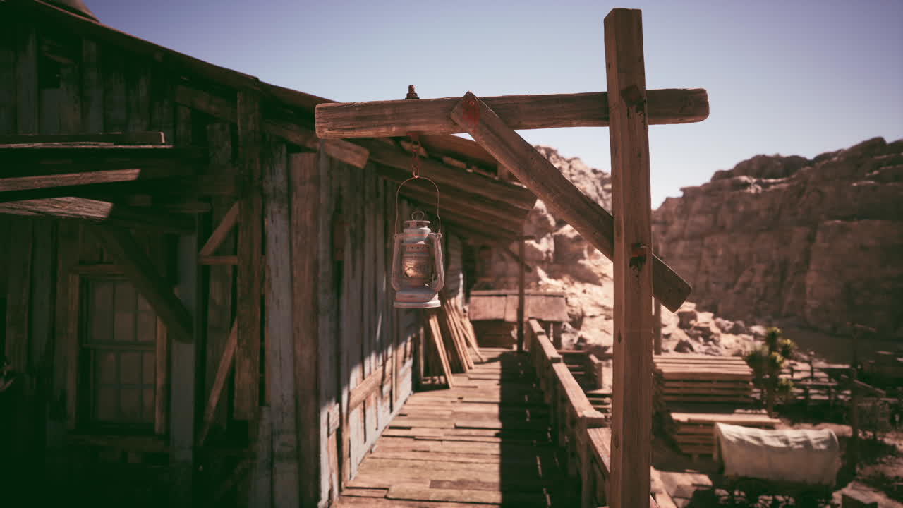 A rustic cabin with a lantern in a desert landscape