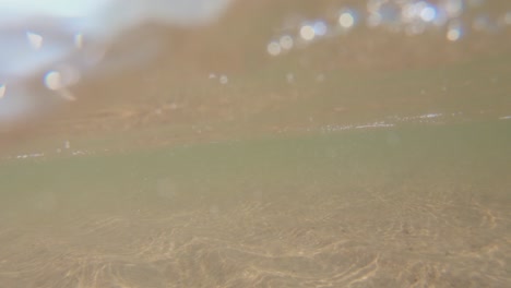 underwater view of sea waves near sandy shore