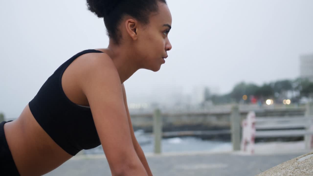 Mixed race woman working out on docks