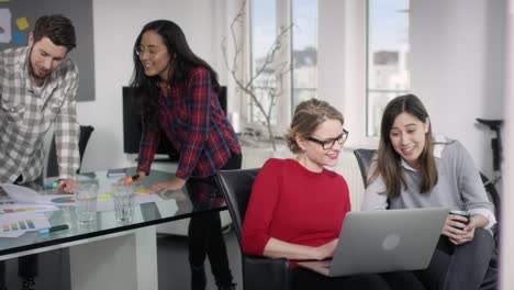 equipo de 4 en una reunión creativa trabajando en papeles y cuadernos en una oficina moderna