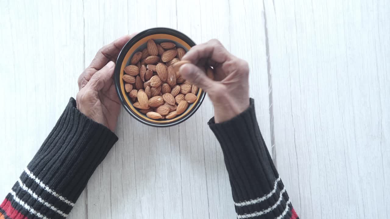 Elderly Person Eating Almonds